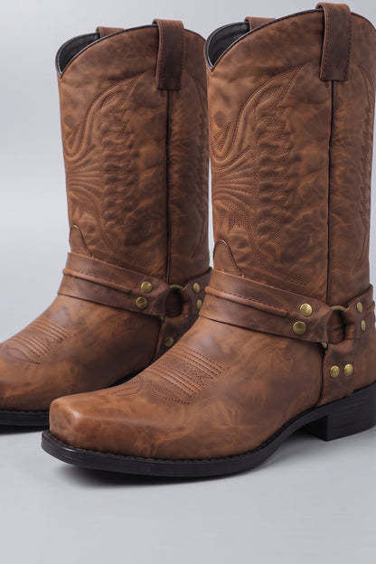 Detail of the metal ring and studded harness strap on men's boots