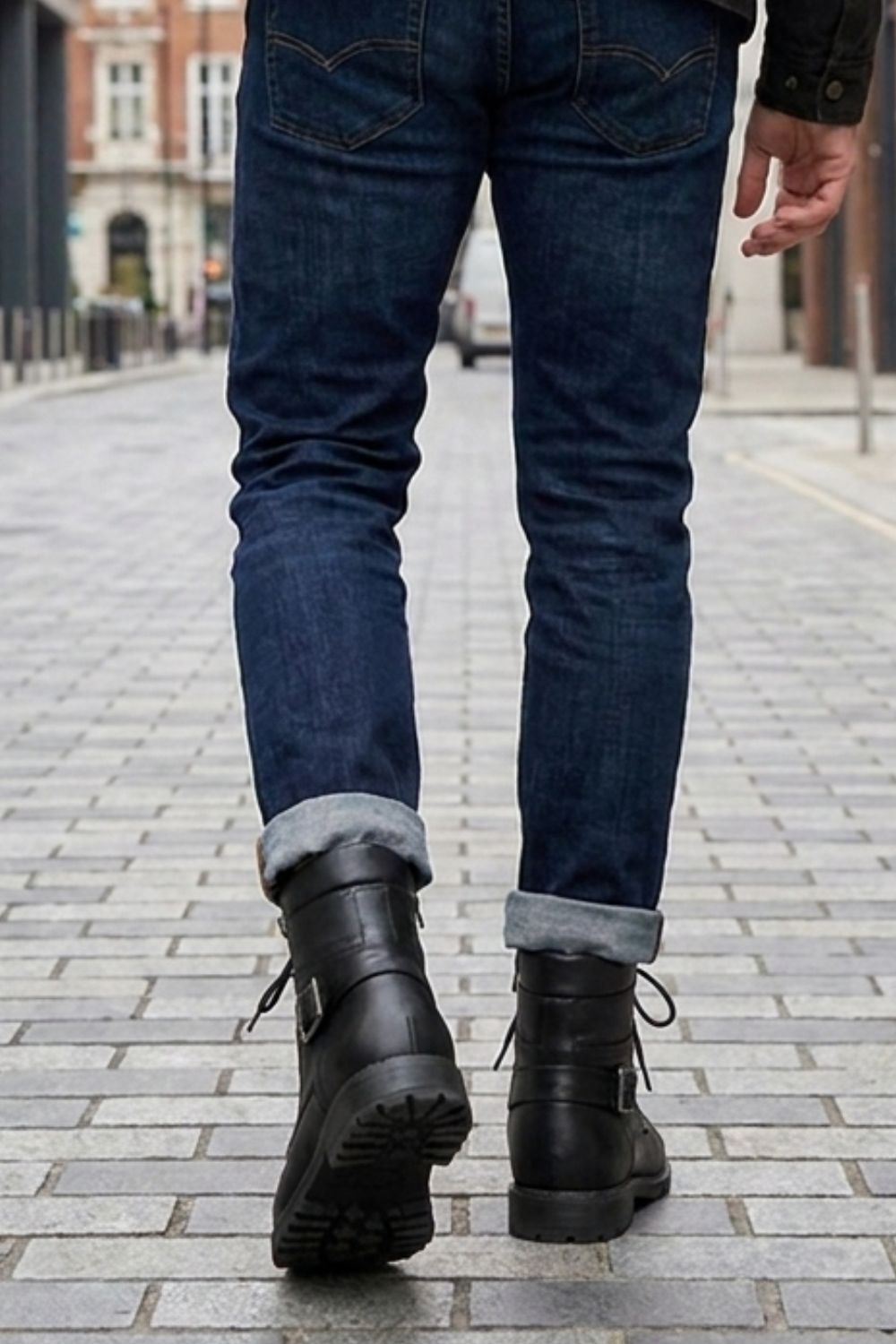 Men's combat boots worn with jeans, rear view on model