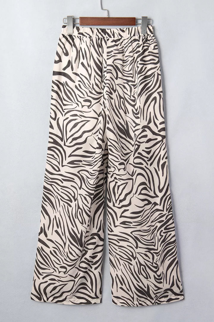 Zebra print drawstring pants on a hanger, angled view of the wide legs