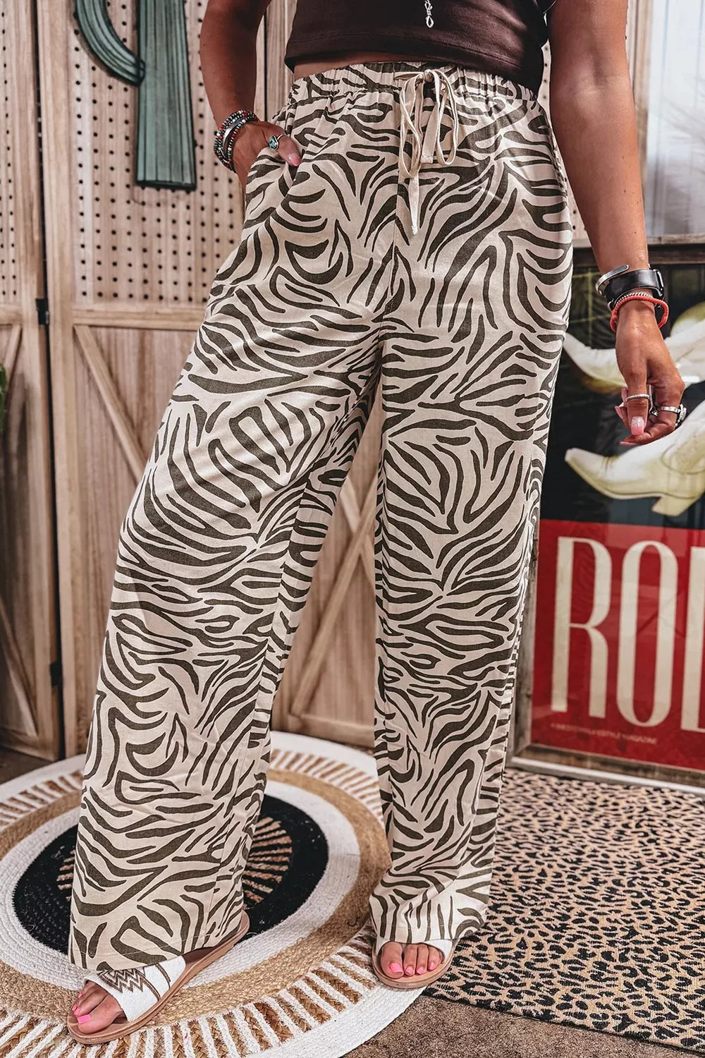 Zebra print wide leg pants front view with a drawstring tie and sandals