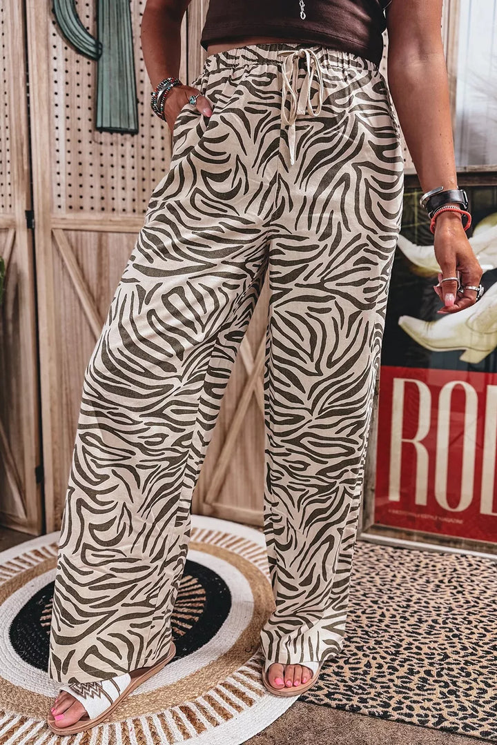 Zebra print wide leg pants front view with a drawstring tie and sandals