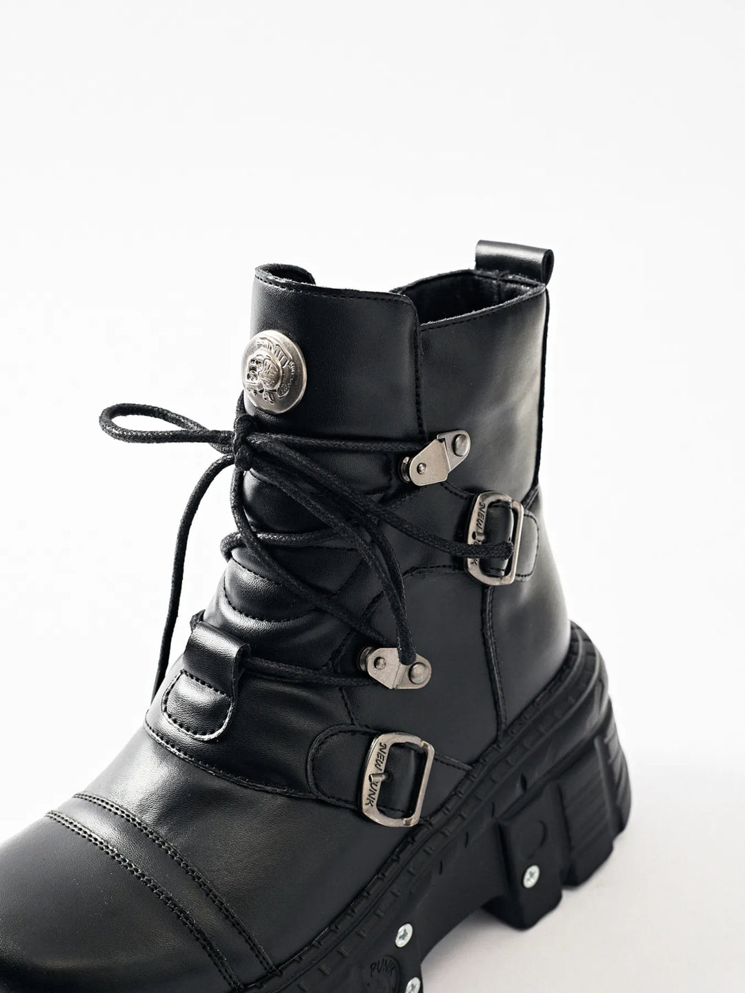 Close-up of black boot laces, buckles and metal emblem details
