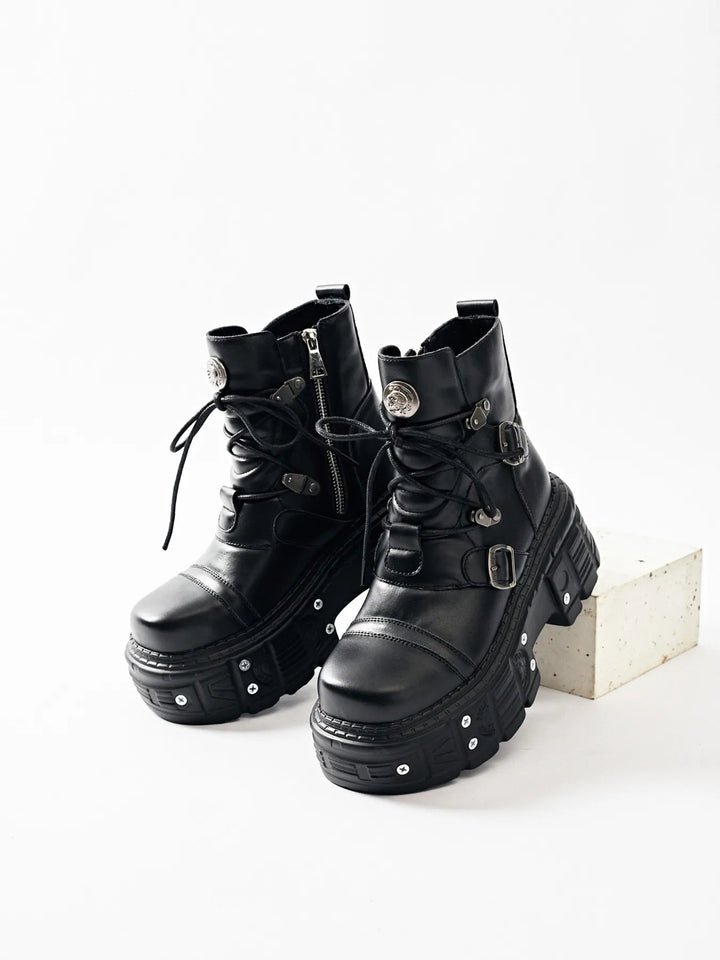 Pair of black platform boots with lace up front on a white backdrop