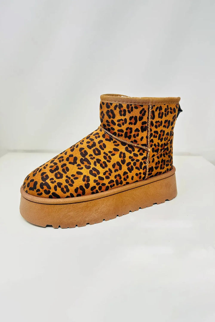 Single leopard print platform ankle boot on a white background, side angle