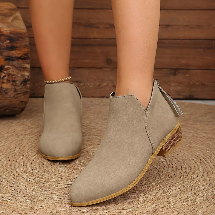 Taupe low heel ankle boots, front three-quarter view with a back tassel zip