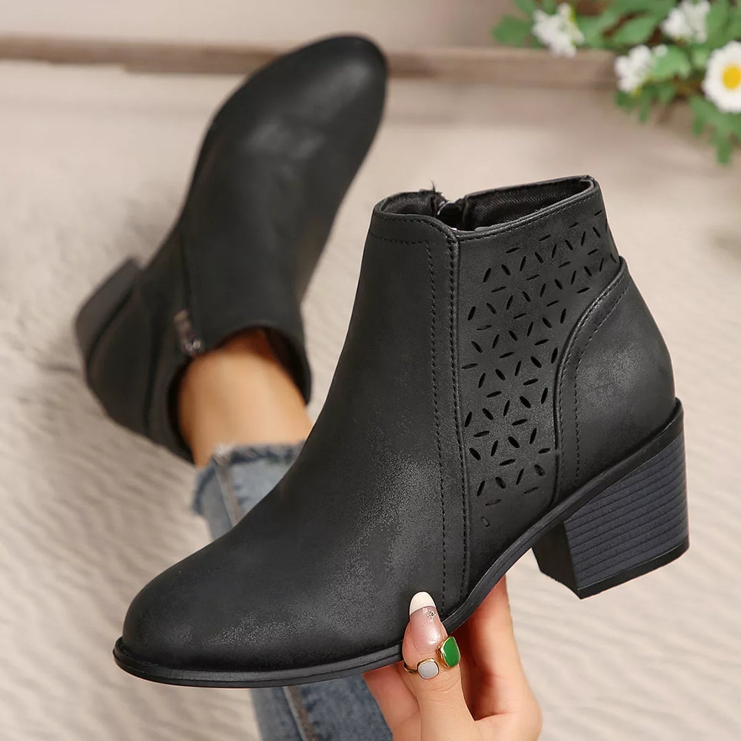 Side view of black block heel ankle boots with cut out panel