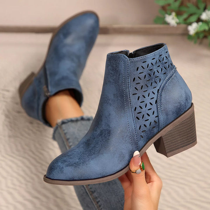 Close-up of denim blue ankle boots with cut out detail and heel
