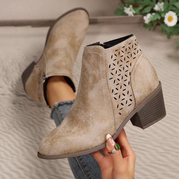 Close-up of taupe ankle boots with perforated cut out side panel