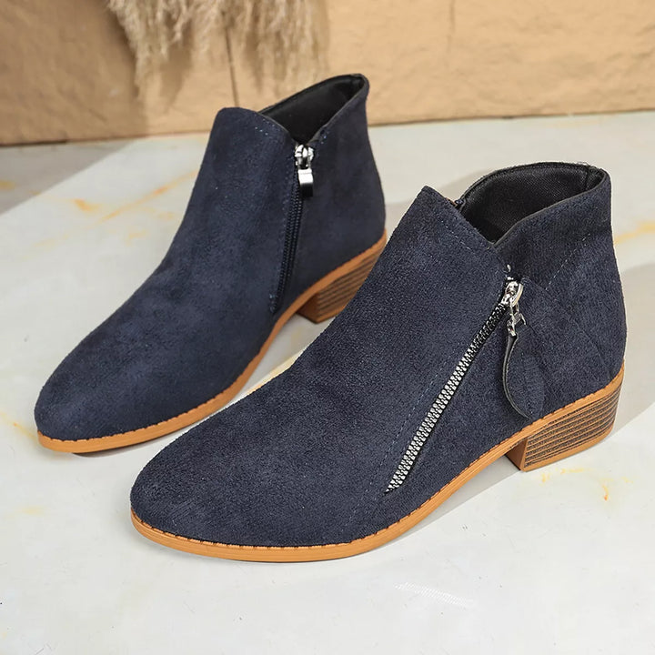 Pair of navy pointed toe ankle boots with metal zip