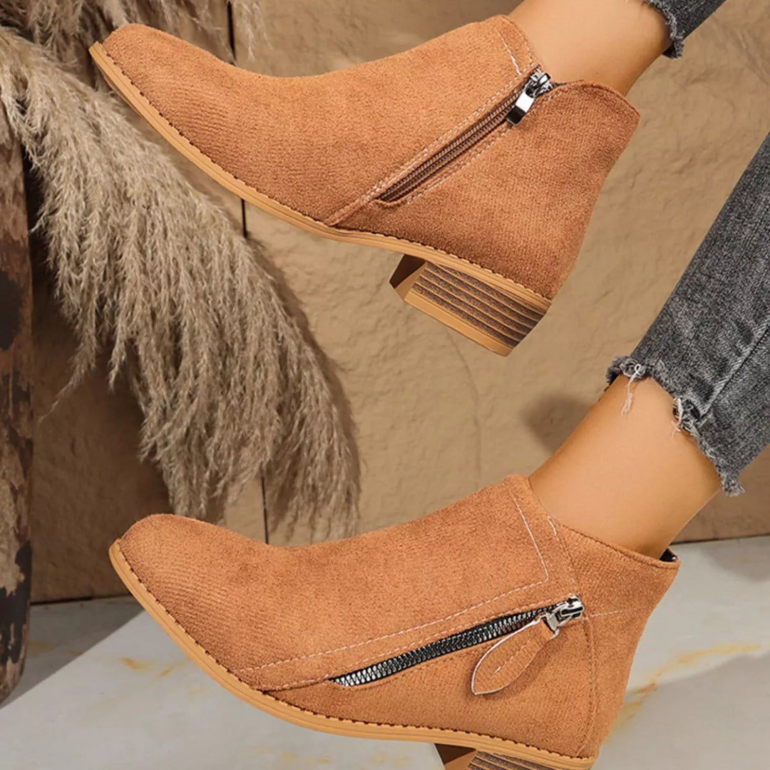 Tan pointed toe ankle boots seen from the zipper side