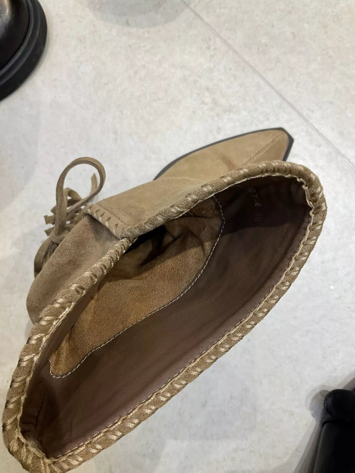 Inside of tan ankle boot showing the lining and stitched edge