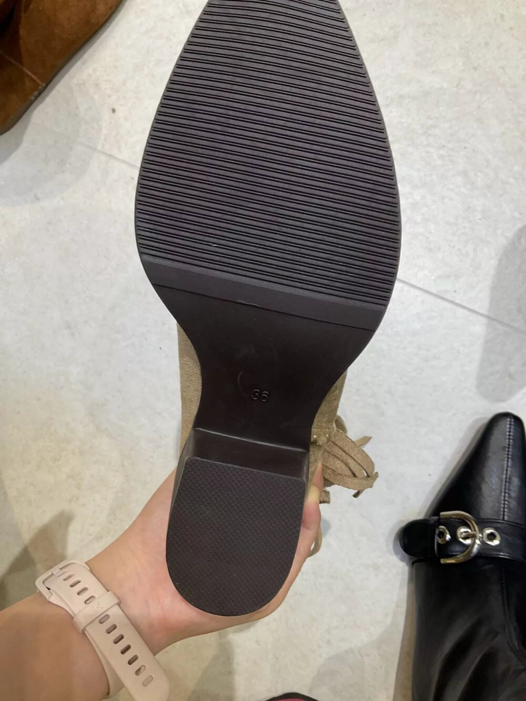 Sole and block heel of the ankle boot held in hand