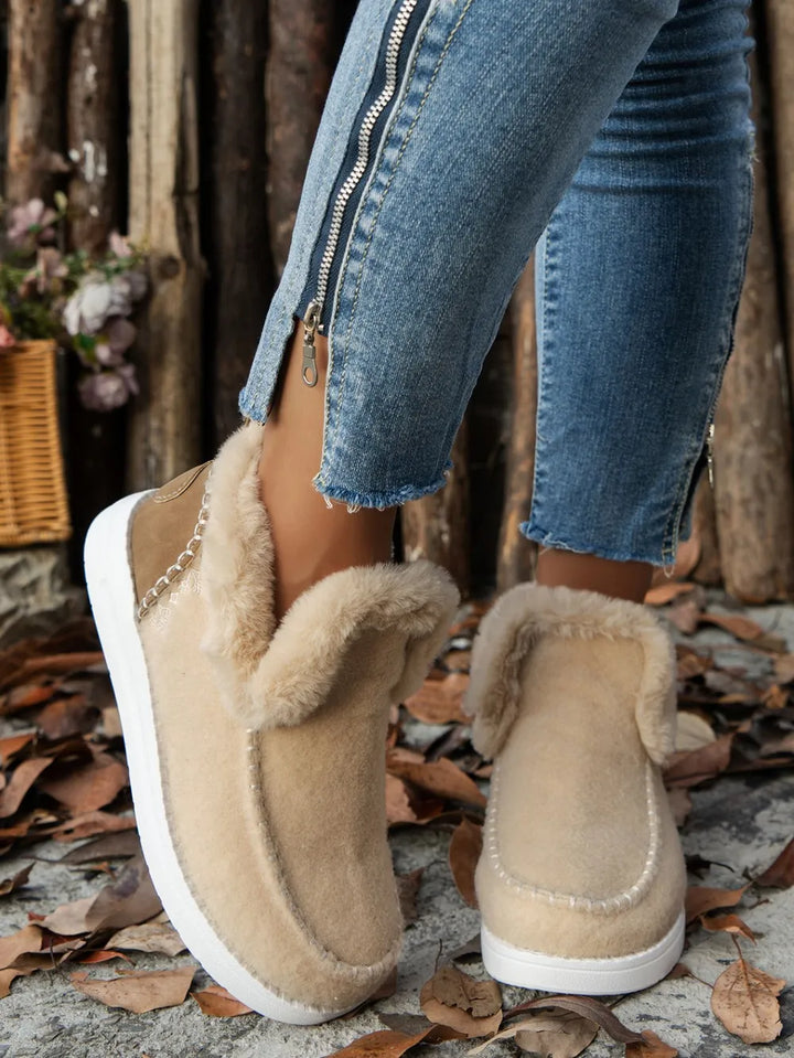 Beige studded slip on ankle boots with a fur-look cuff, worn with jeans