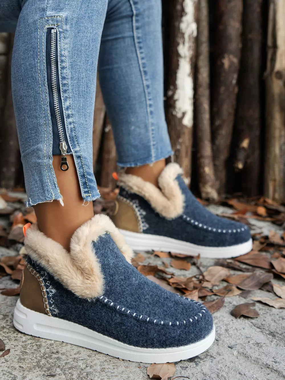 Navy studded ankle boot, side view on foot with a zip detail on the jeans