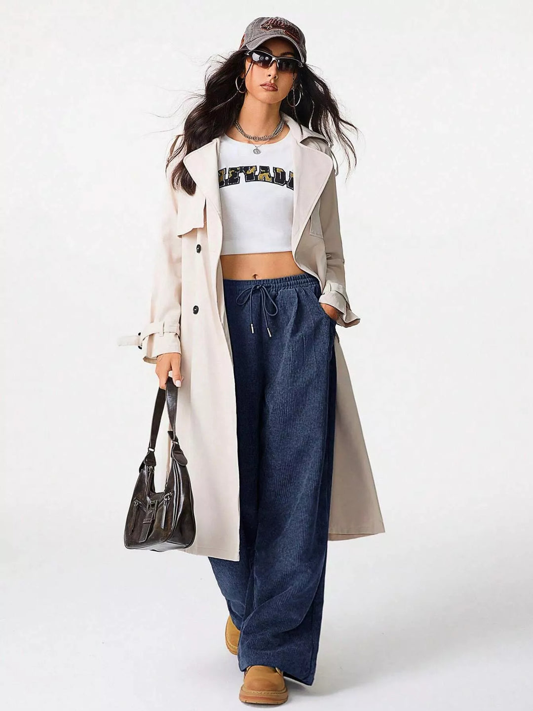 Navy baggy pants styled with a crop top and beige trench coat