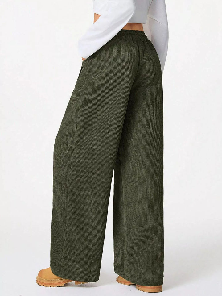 Olive baggy pants seen from the side with tan boots