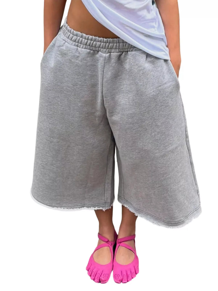 Heather gray baggy shorts with wide legs and frayed hem, front view