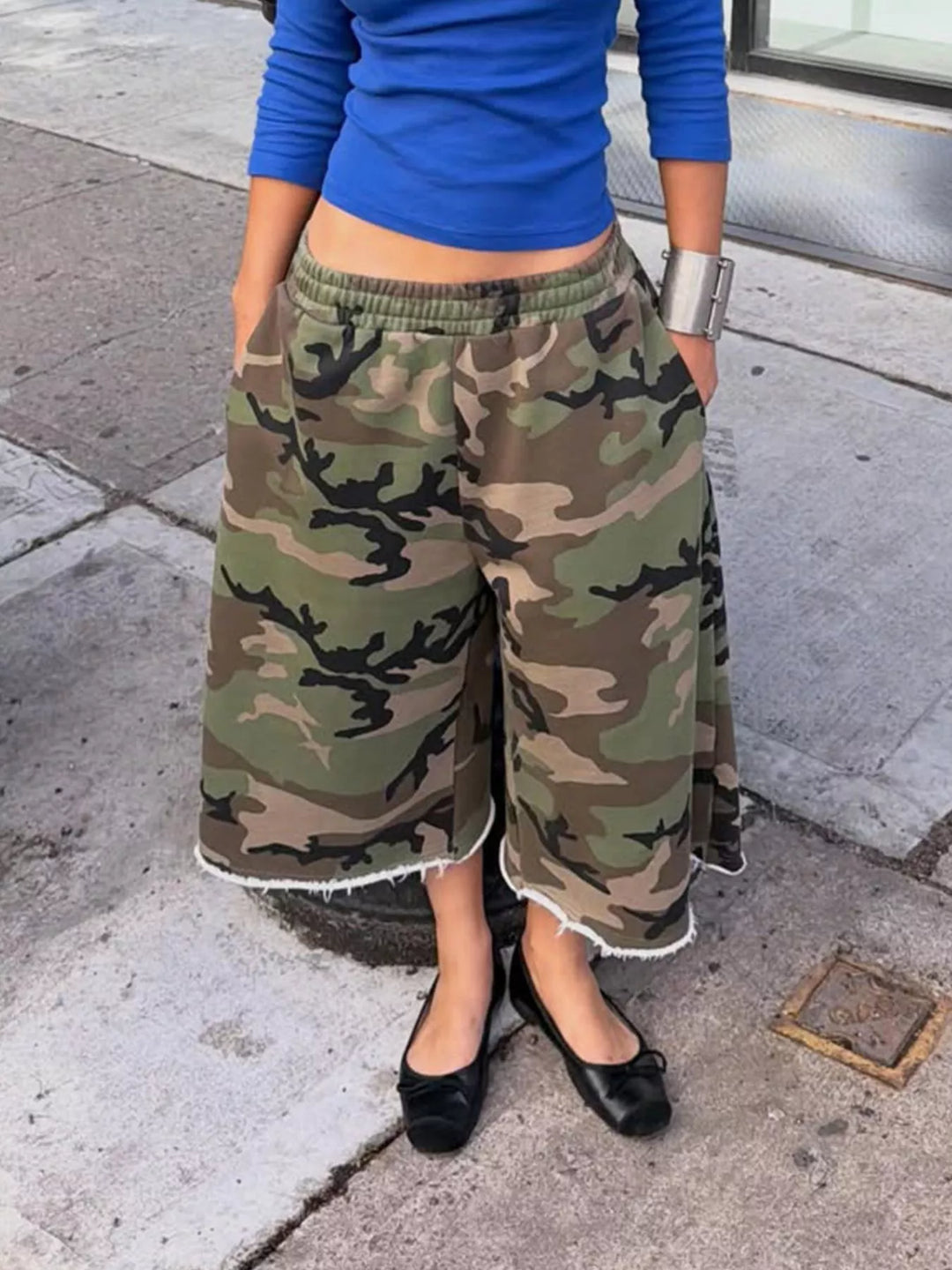 Women's baggy shorts in woodland camo, wide leg knee length with frayed hem, worn with flats