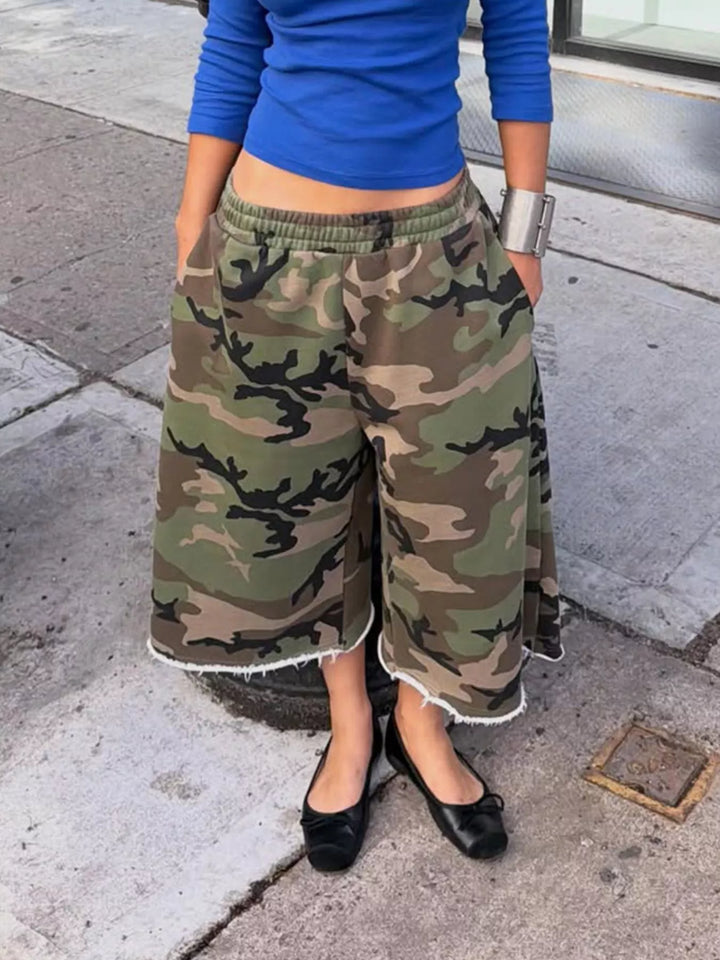 Women's baggy shorts in woodland camo, wide leg knee length with frayed hem, worn with flats