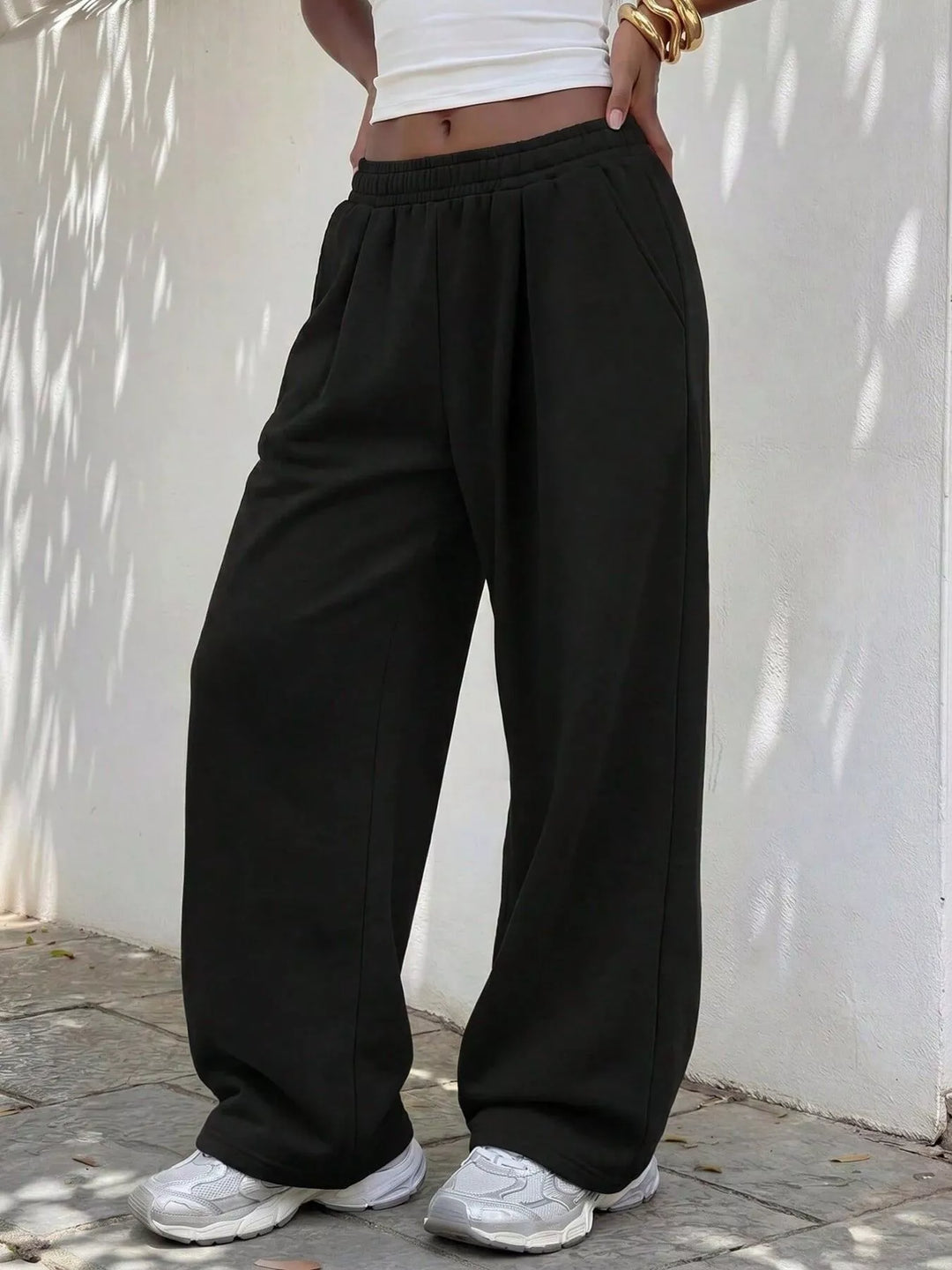 Black wide leg sweatpants with elastic waist, full length view