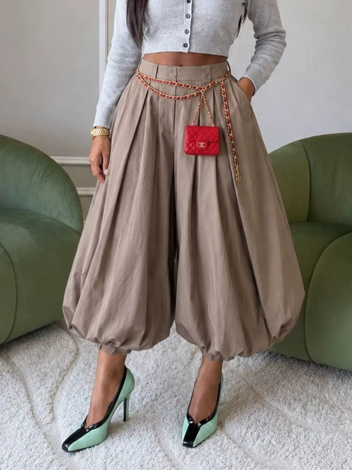 Khaki bubble silhouette balloon pants styled with a mini chain bag and pumps