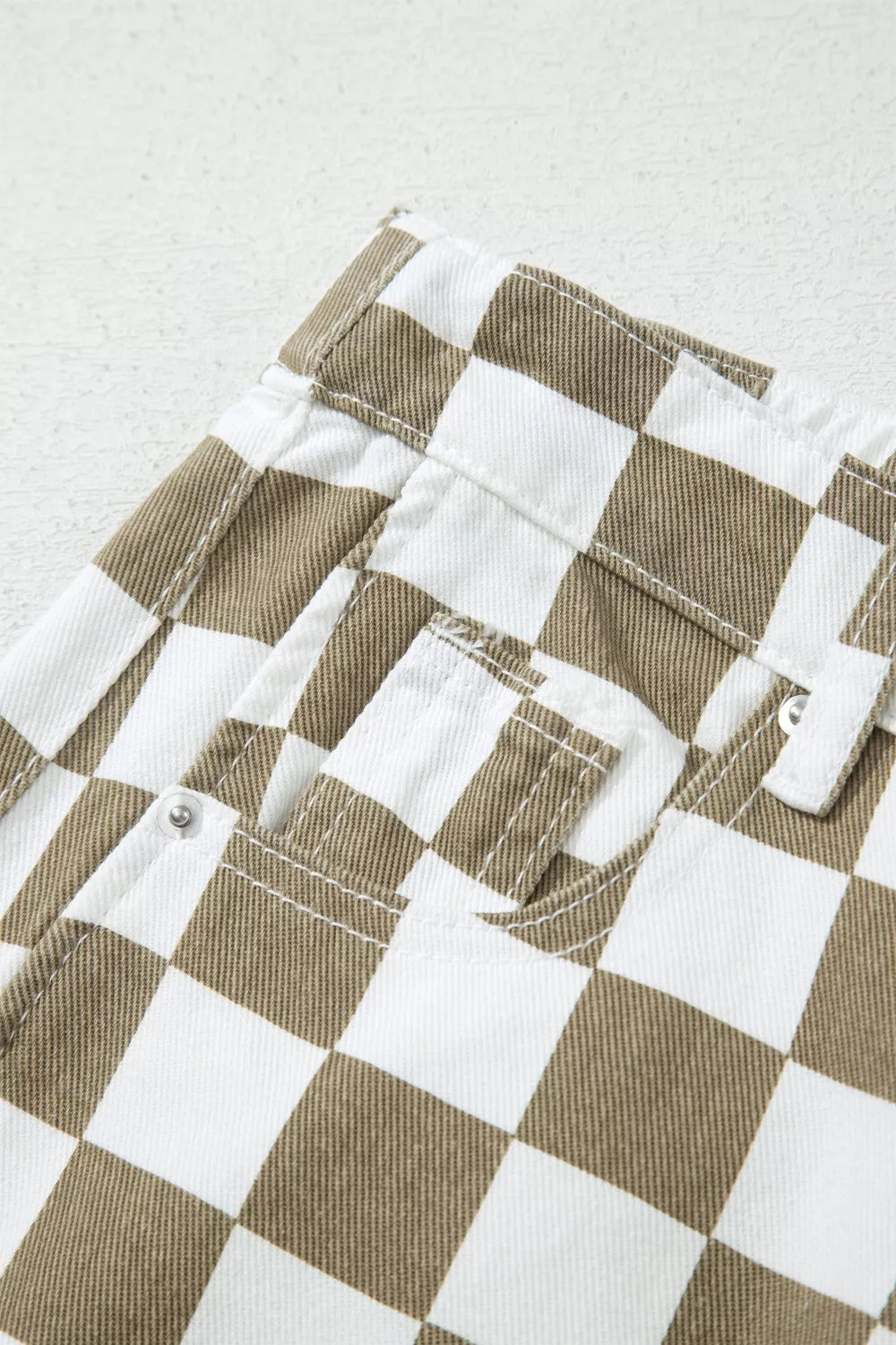 Detail of the front pocket and stitching on the checkerboard pants