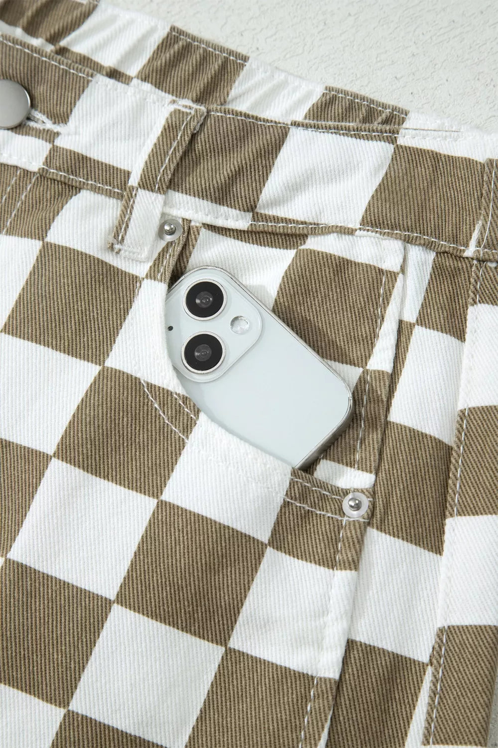 Front pocket holding a phone on the checkerboard barrel leg pants