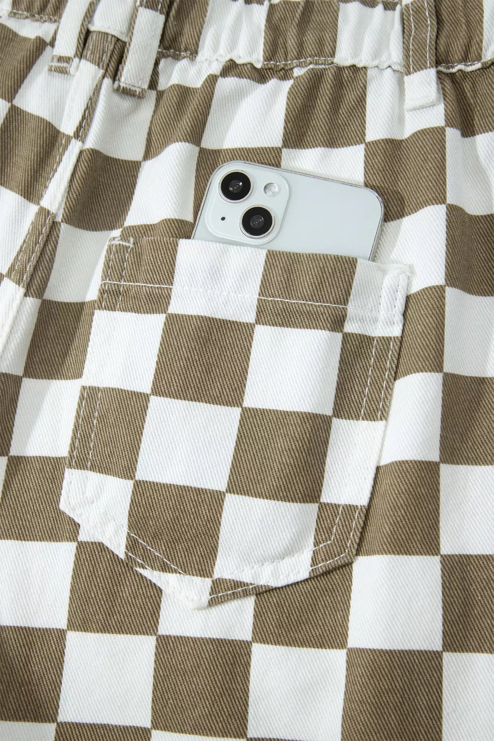 Back pocket and elastic waistband of the checkerboard pants with a phone
