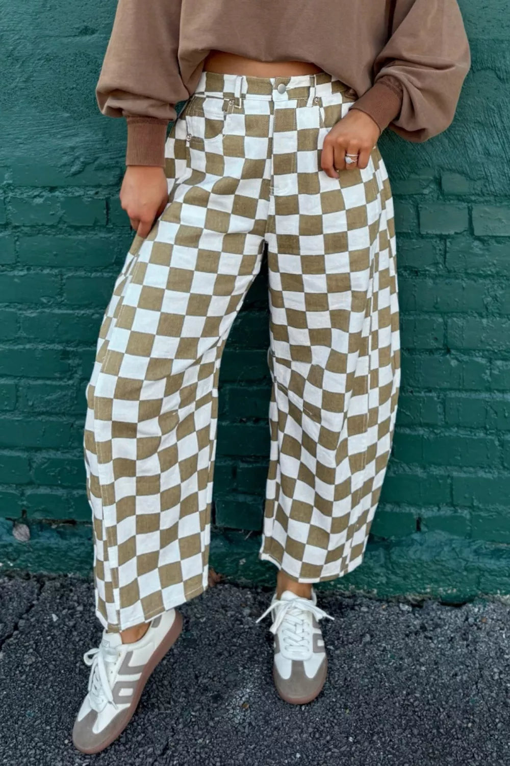 Khaki checkerboard barrel leg pants worn with a brown cropped sweatshirt