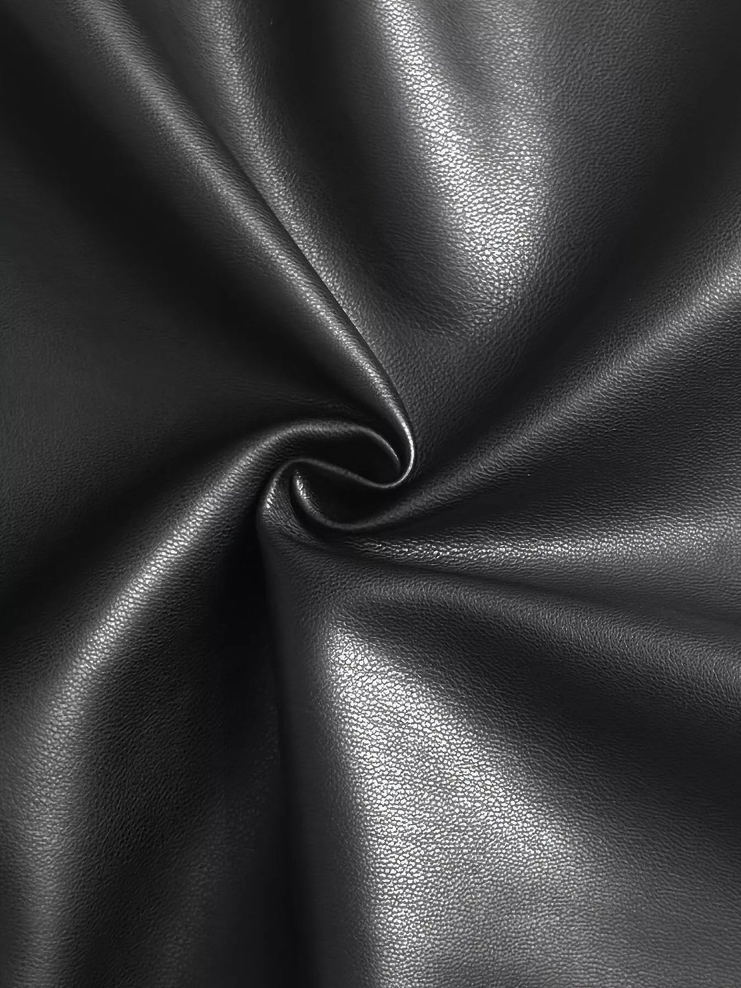 Close-up of the smooth black fabric twisted in a swirl