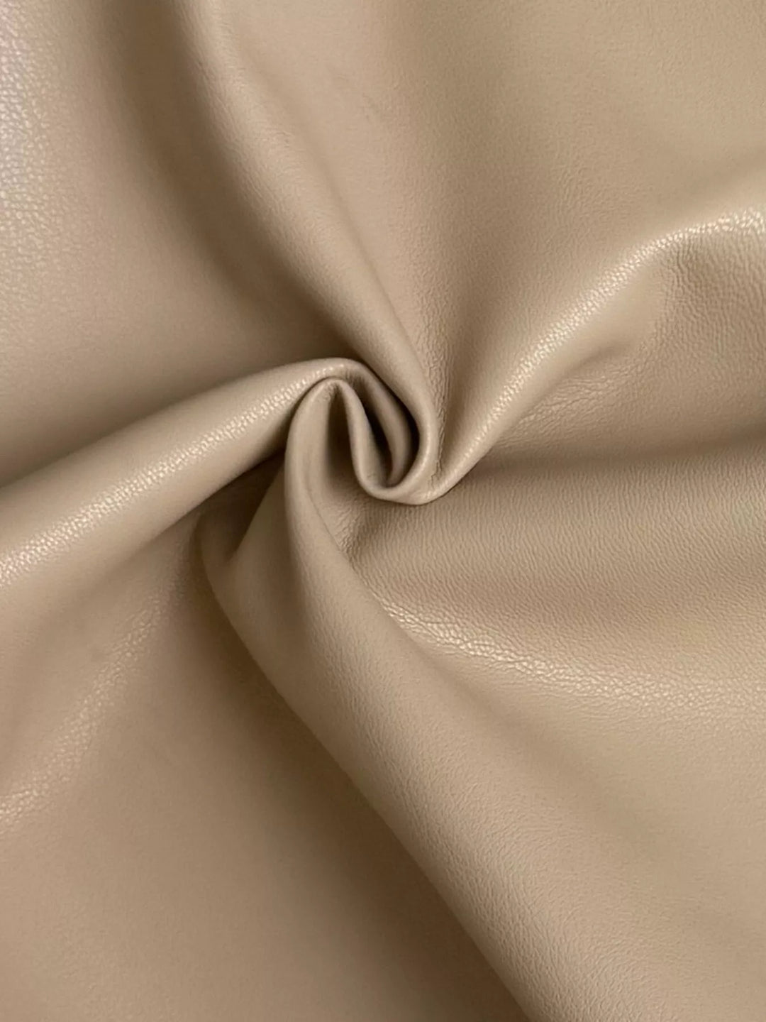 Close-up of the smooth camel fabric folded in a swirl