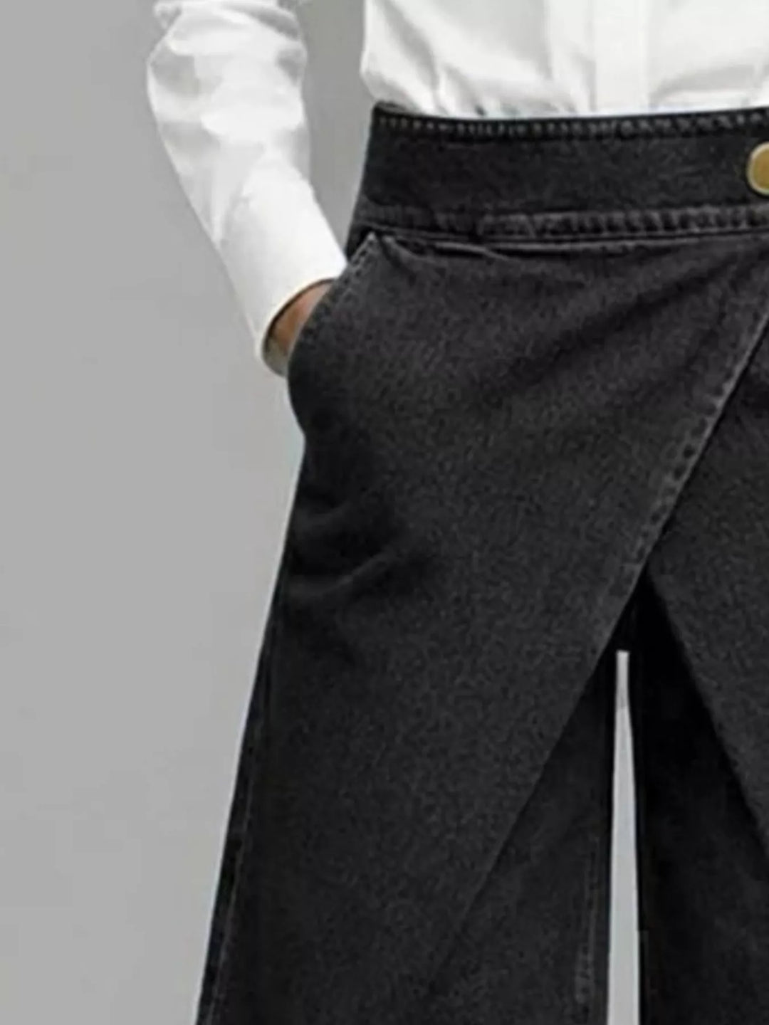 Close-up of the black wrap front waist and pocket on the Bermuda shorts