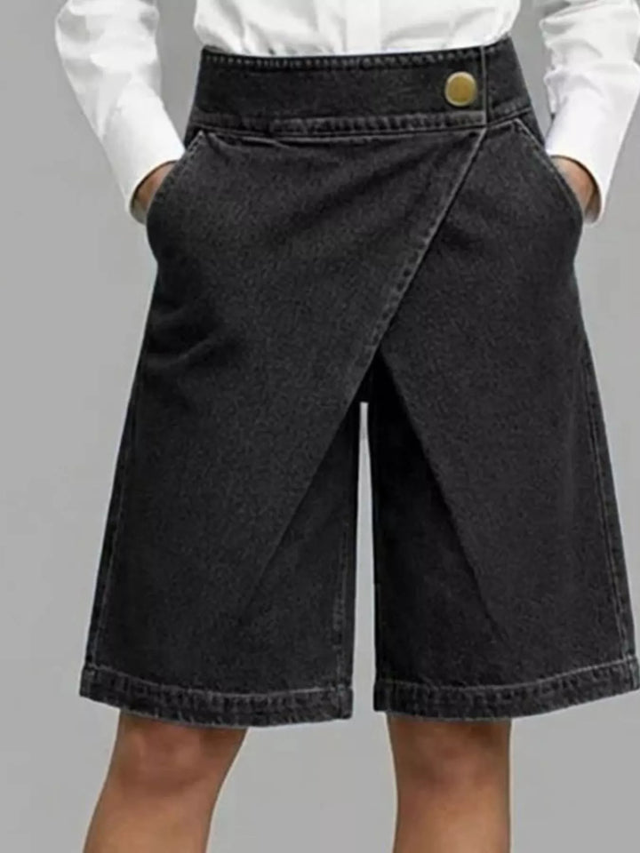 Black knee length denim style shorts, front view showing the overlapping wrap panel