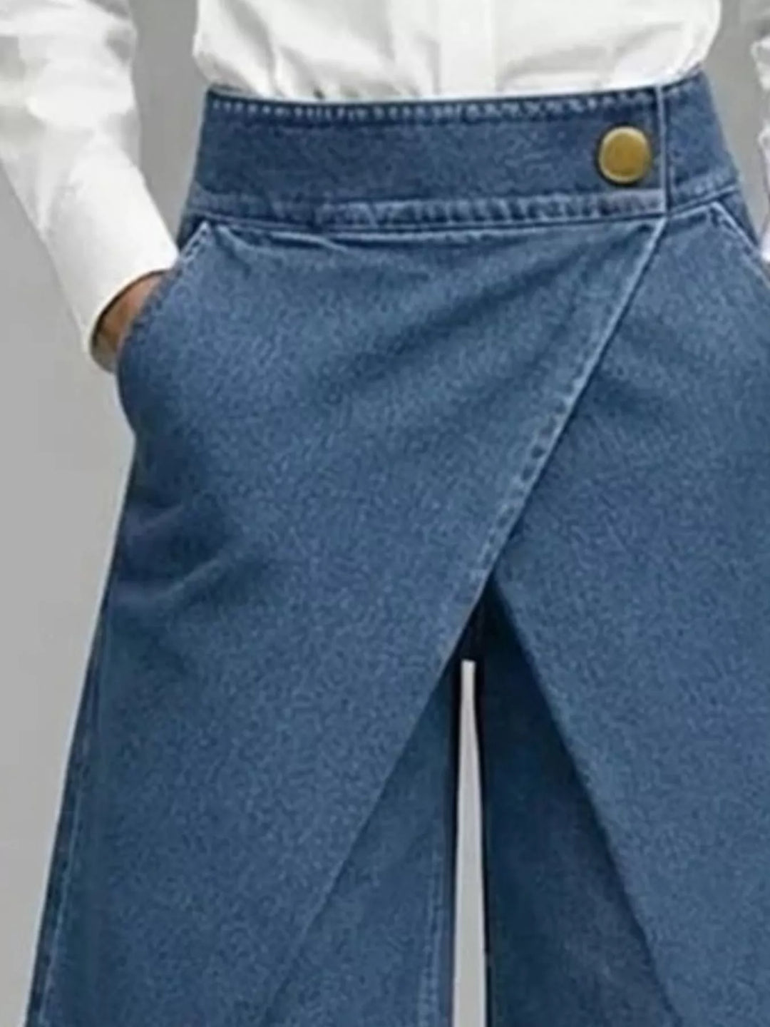Close-up of the dusty blue wrap front waistband with a gold button