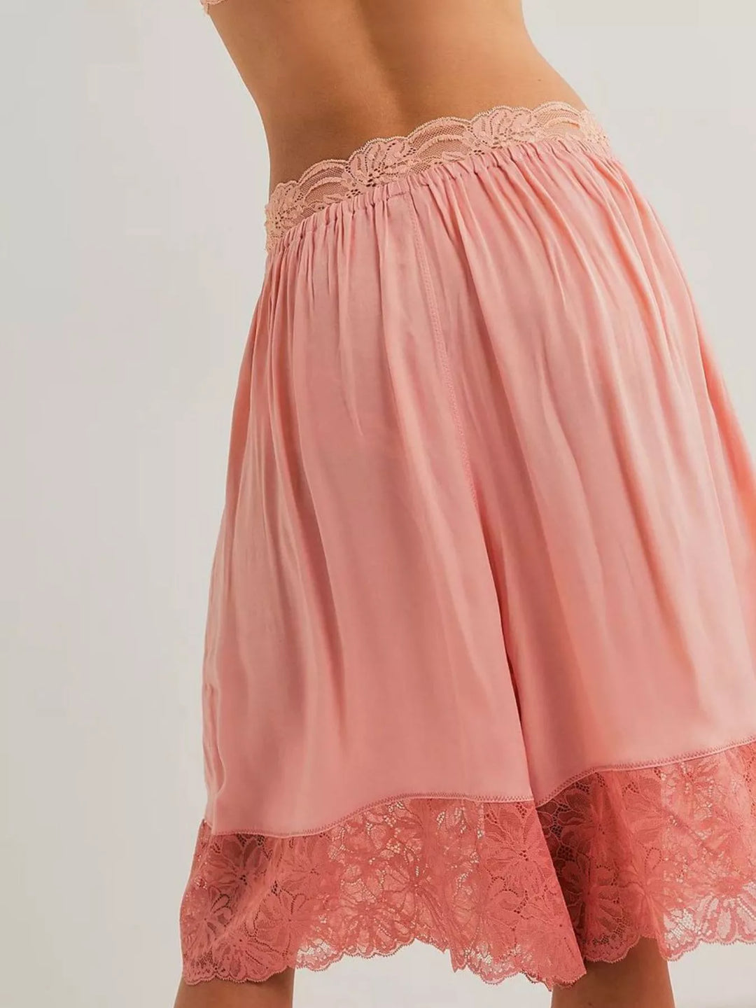 Back view of pink Bermuda shorts showing the lace trim hem