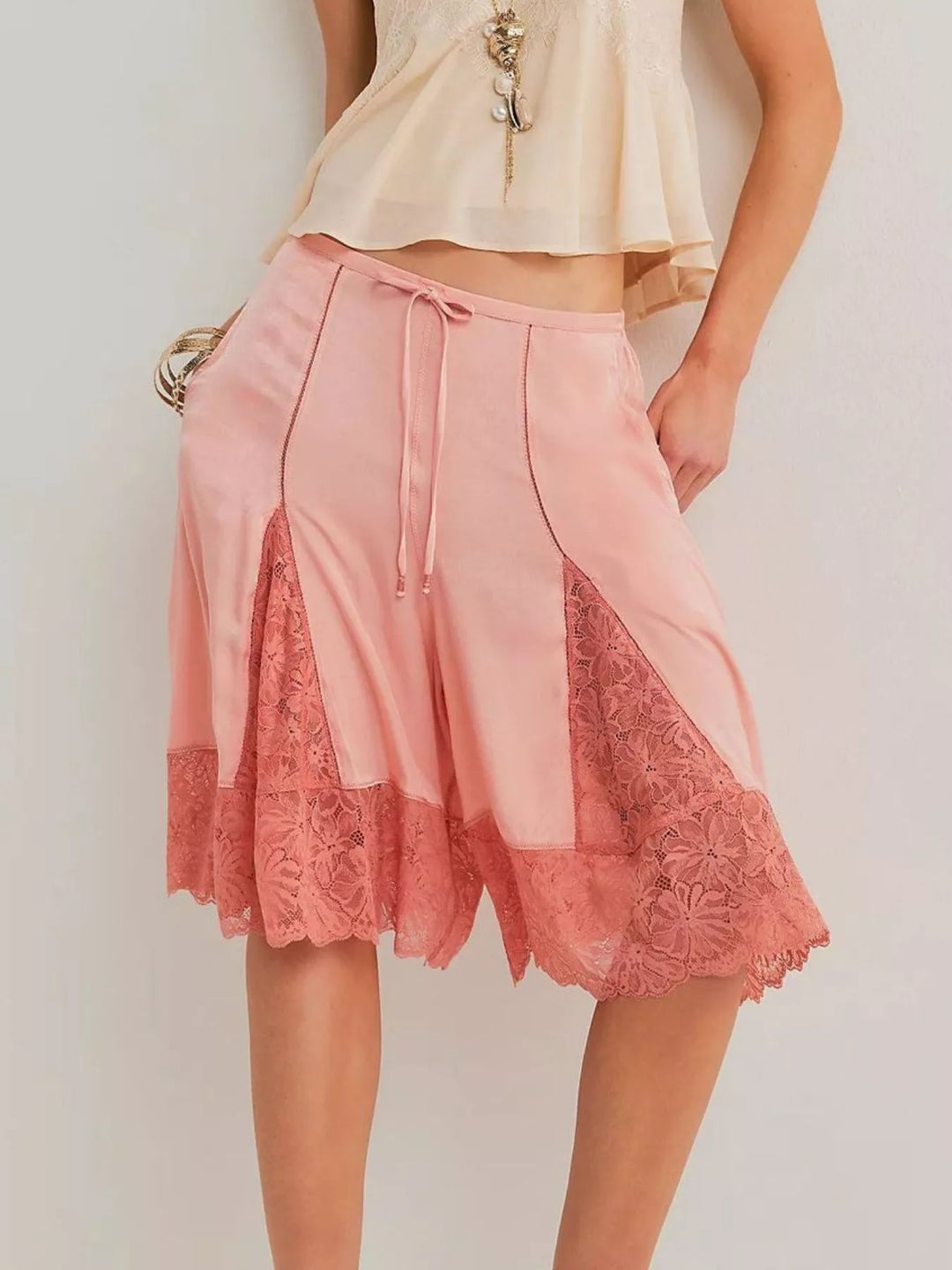 Women's Bermuda shorts in pink with lace trim hem, front view