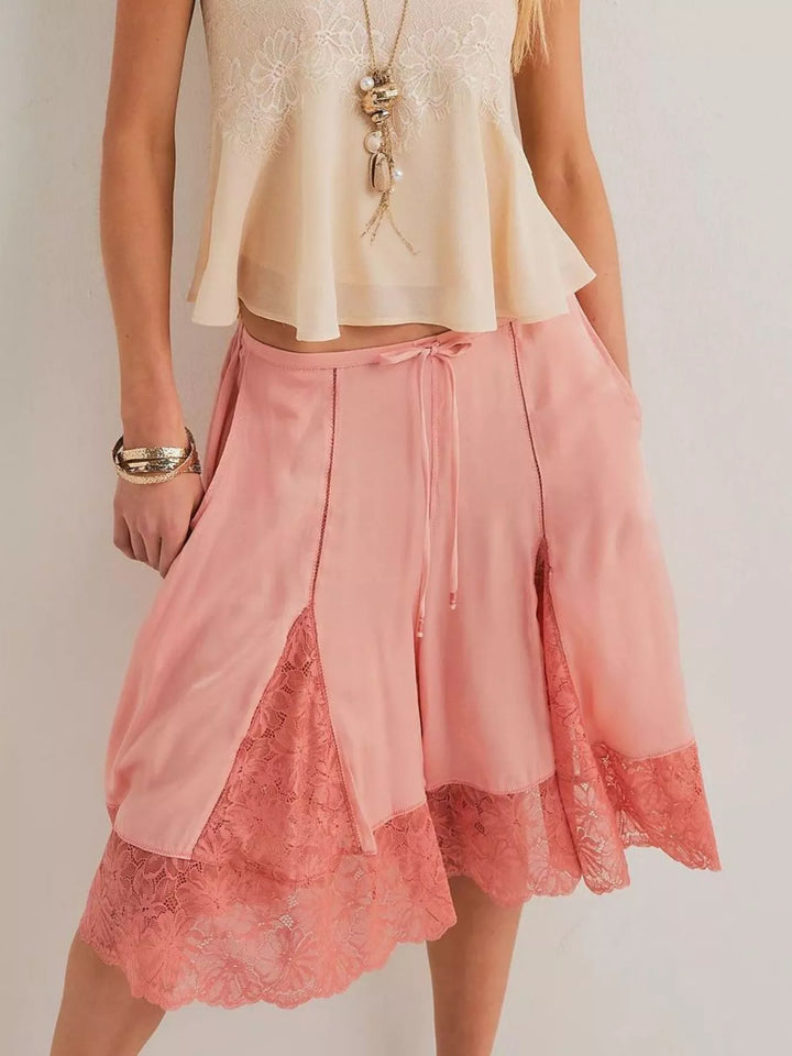 Pink lace trim Bermuda shorts worn with a beige camisole