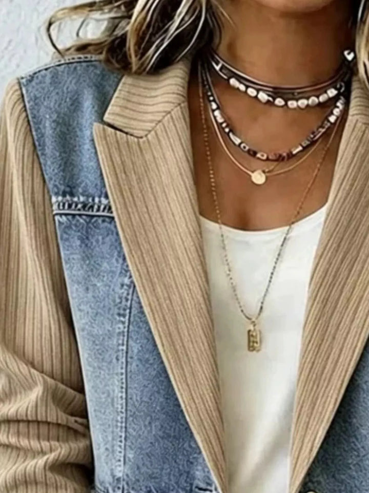 Close-up of beige blazer jacket notch lapel and denim shoulder panel