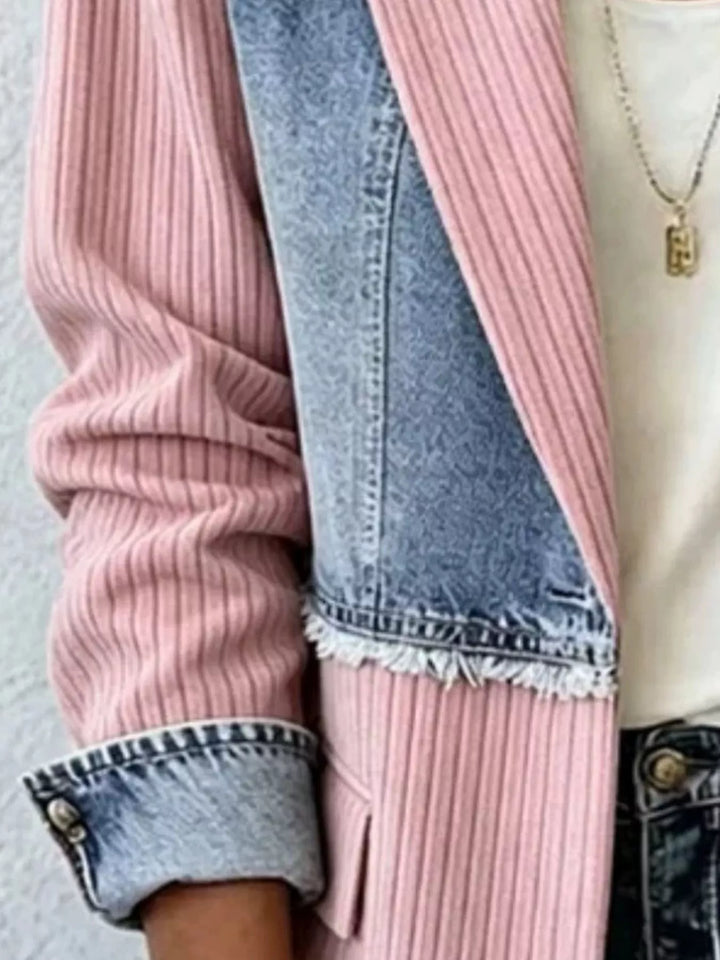 Close-up of blush pink blazer sleeve with rolled denim cuff and frayed hem