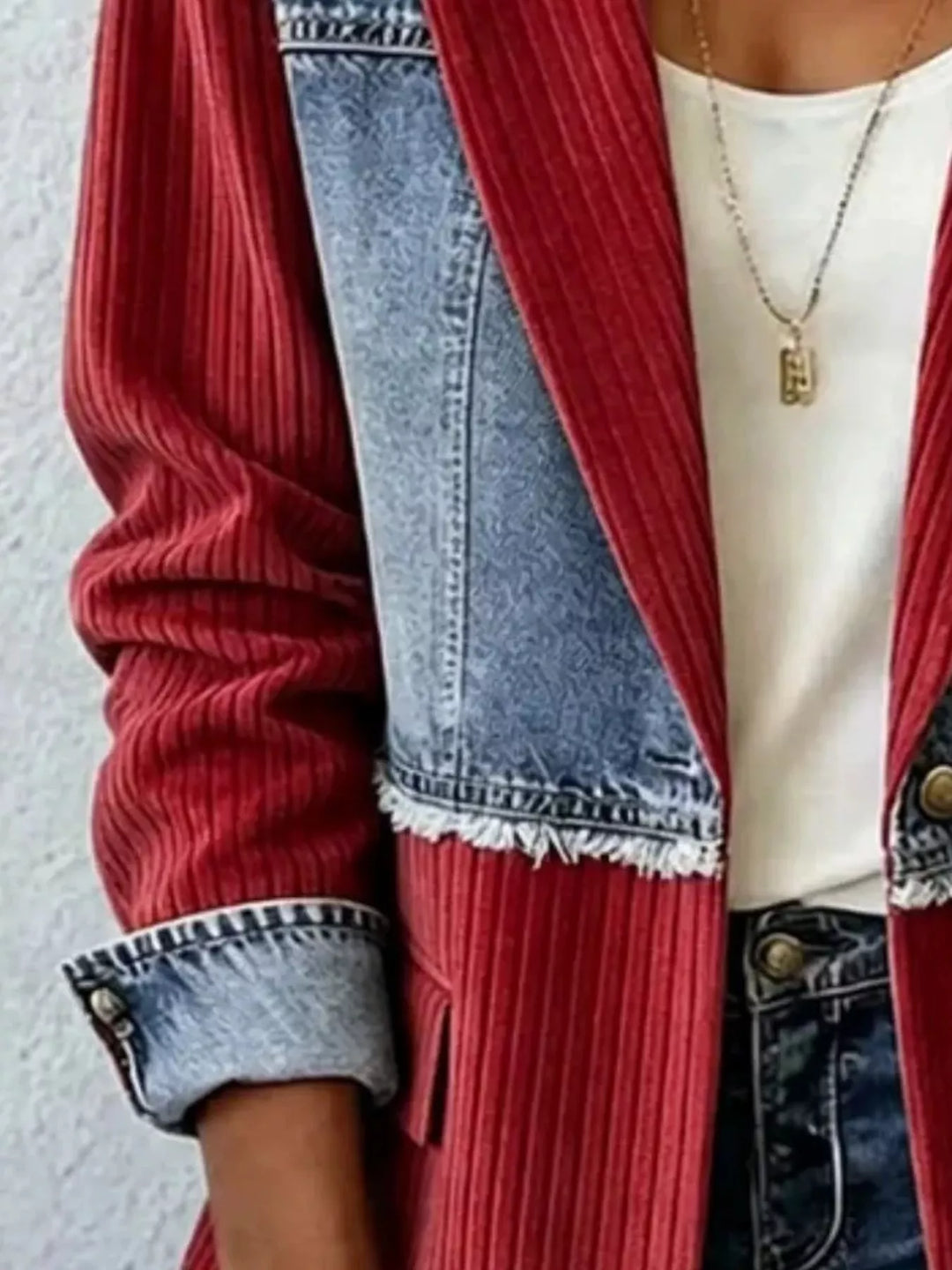 Close-up of burgundy ribbed blazer front with denim lapel and frayed seam