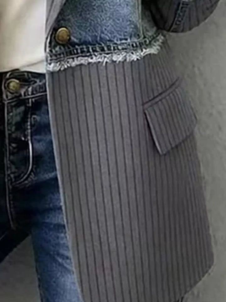 Close-up of charcoal blazer flap pocket and frayed denim waist seam