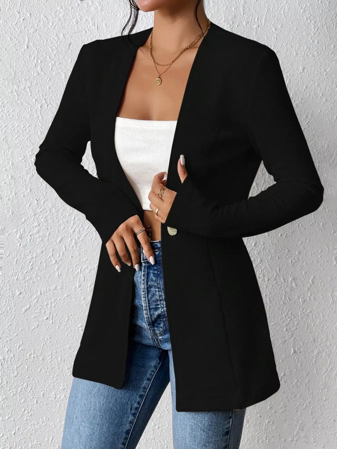 Black one button blazer on-model, hand resting at the waist