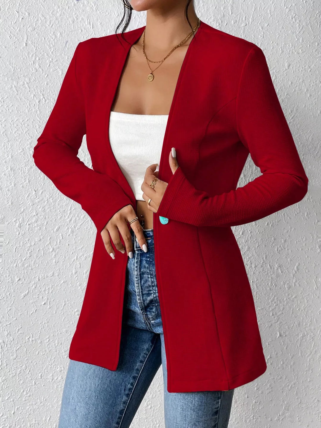 Red blazer with the sleeve pulled up, hand at the waist