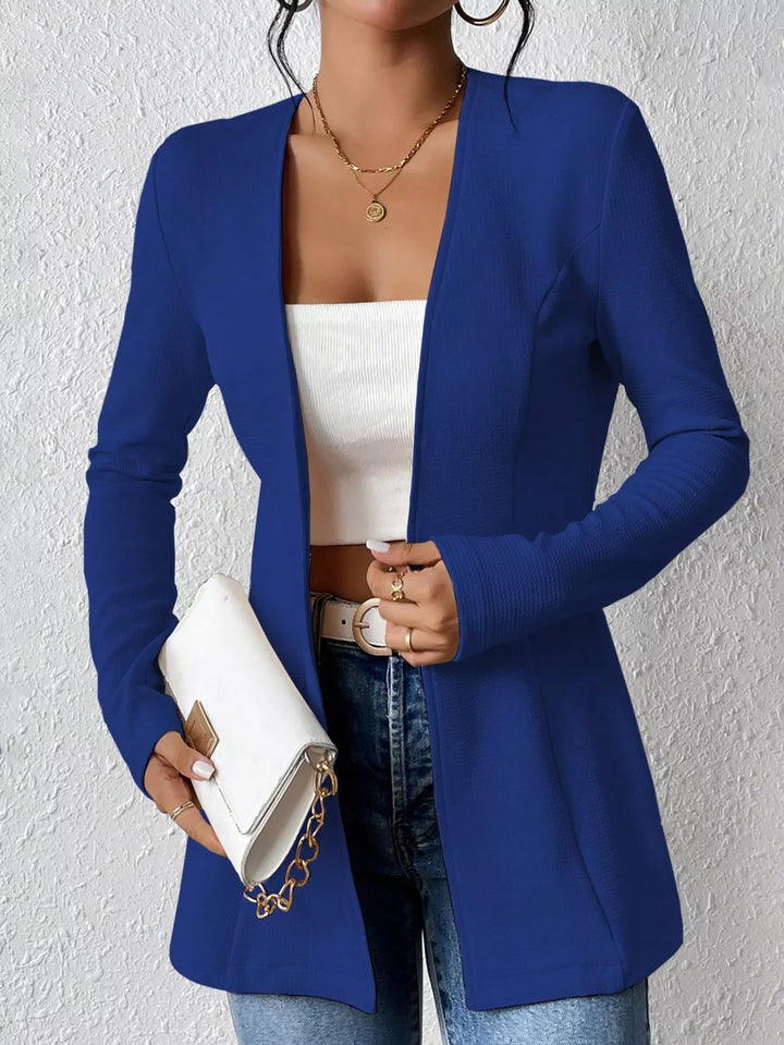 Royal blue open front blazer styled with a white clutch bag