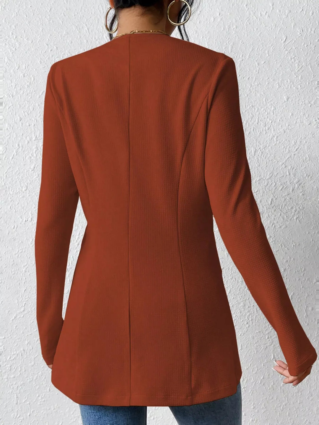 Rust collarless blazer from the back with a fitted shape