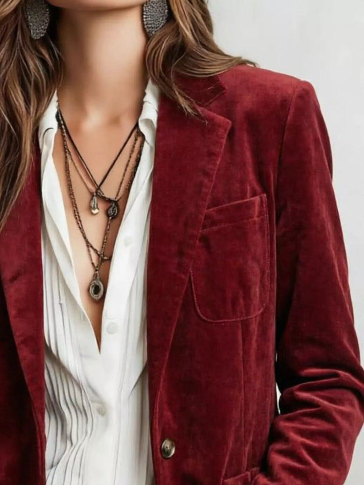 Close-up of the burgundy single breasted blazer and chest patch pocket