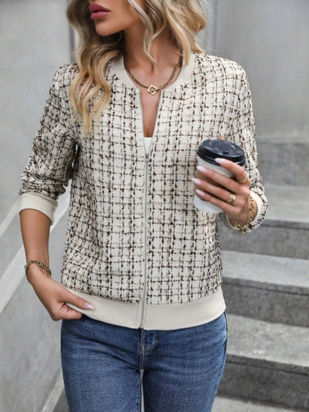 Cream tweed look cropped bomber jacket with a ribbed hem, holding a coffee cup