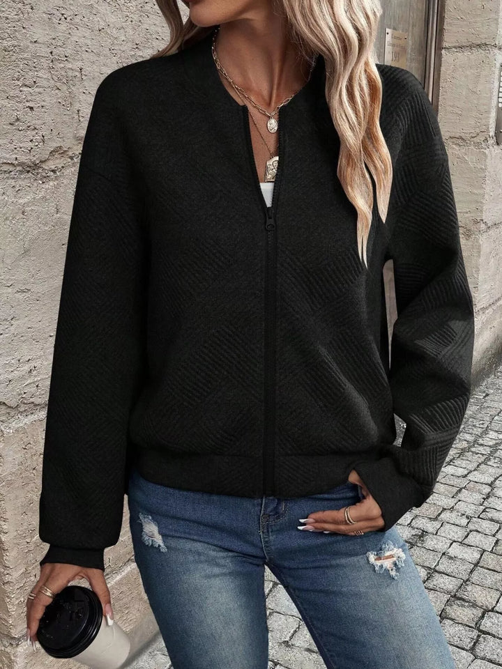 Black cropped bomber jacket with hand on hip, front view