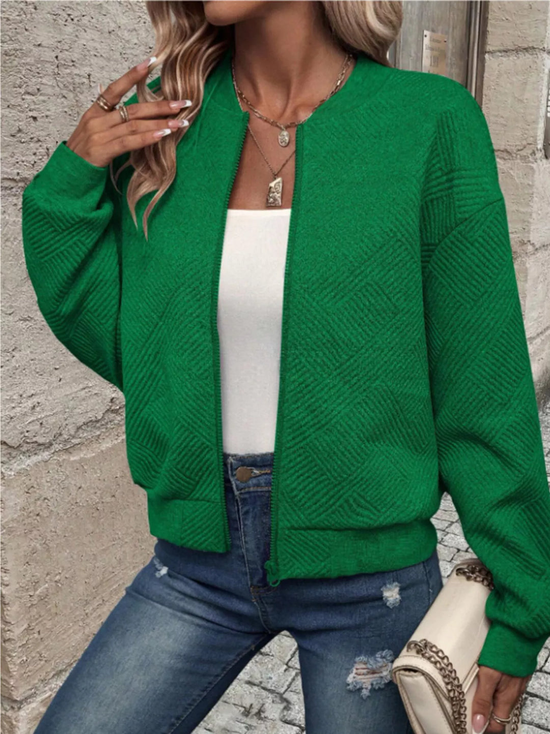 Emerald green cropped quilted bomber jacket worn open over a white top