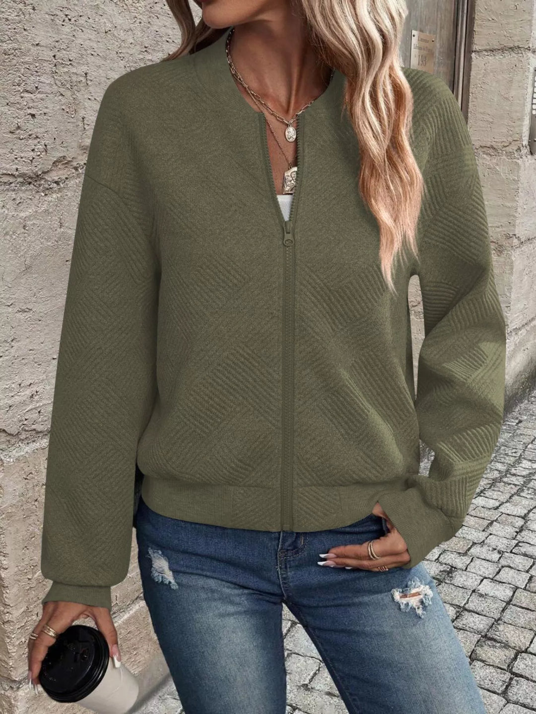 Olive green cropped bomber jacket zipped up, front view with jeans
